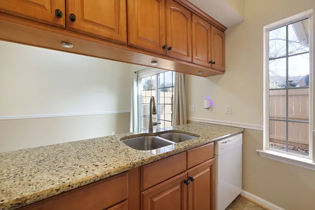 a kitchen with granite countertop cabinets sink and window