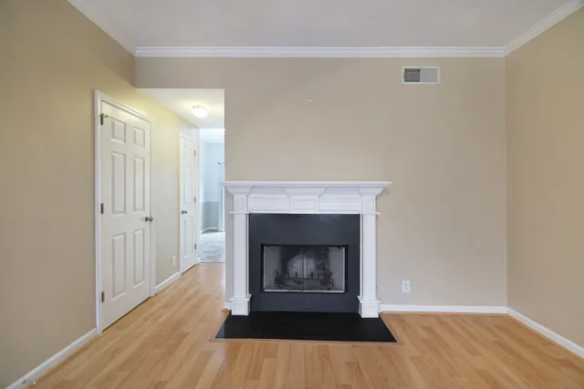 a view of a livingroom with wooden floor and a fireplace