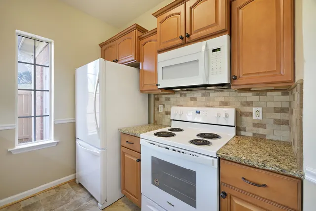 a kitchen with granite countertop cabinets stainless steel appliances and a sink