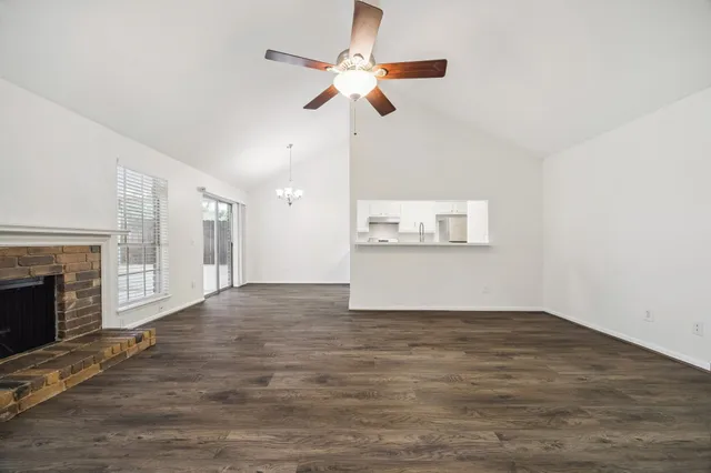 a view of an empty room with a fireplace and a window