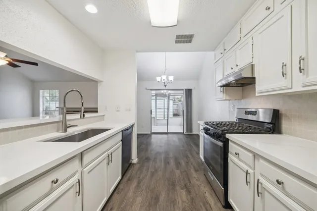 a kitchen with stainless steel appliances granite countertop a sink stove and cabinets