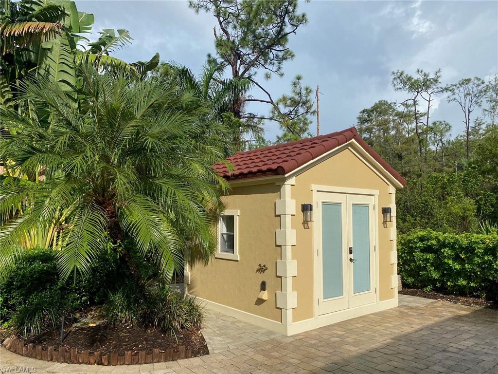 4948 Coach Lane Naples, FL 34114 - Photo 11 of 16 a view of a brick house with plants and large tree
