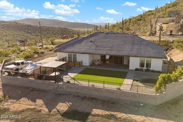 a aerial view of a house with table and chairs under an umbrella
