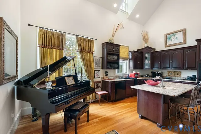 a open kitchen with a stove a sink dishwasher a dining table and chair with wooden floor