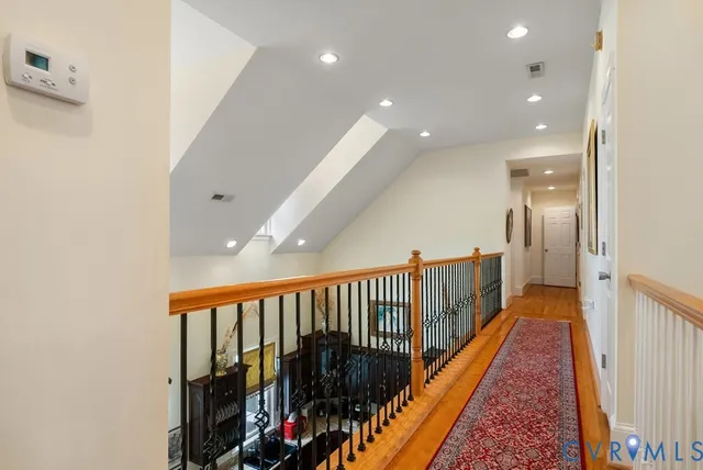 a view of a hallway with wooden floor and stairs