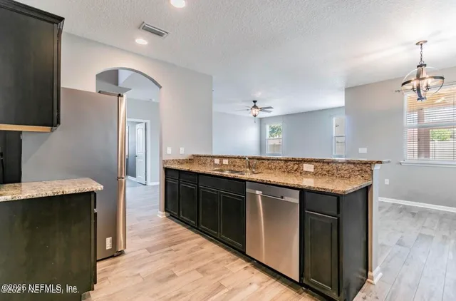 a kitchen with a stove and a wooden floor