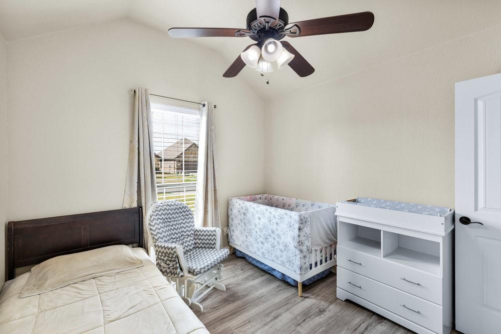 118 Cherokee Street Greenville, TX 75402 - Photo 11 of 19 a bedroom with a bed and a chandelier
