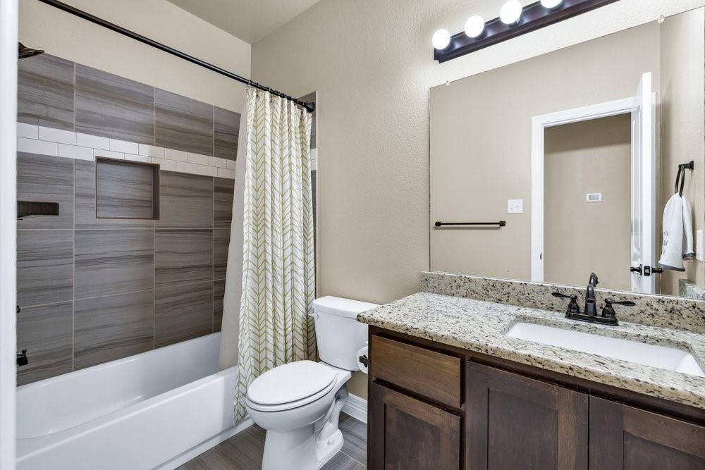 118 Cherokee Street Greenville, TX 75402 - Photo 12 of 19 a bathroom with a granite countertop sink toilet and shower