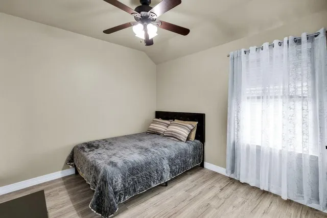 a view of a room with a ceiling fan and wooden floor