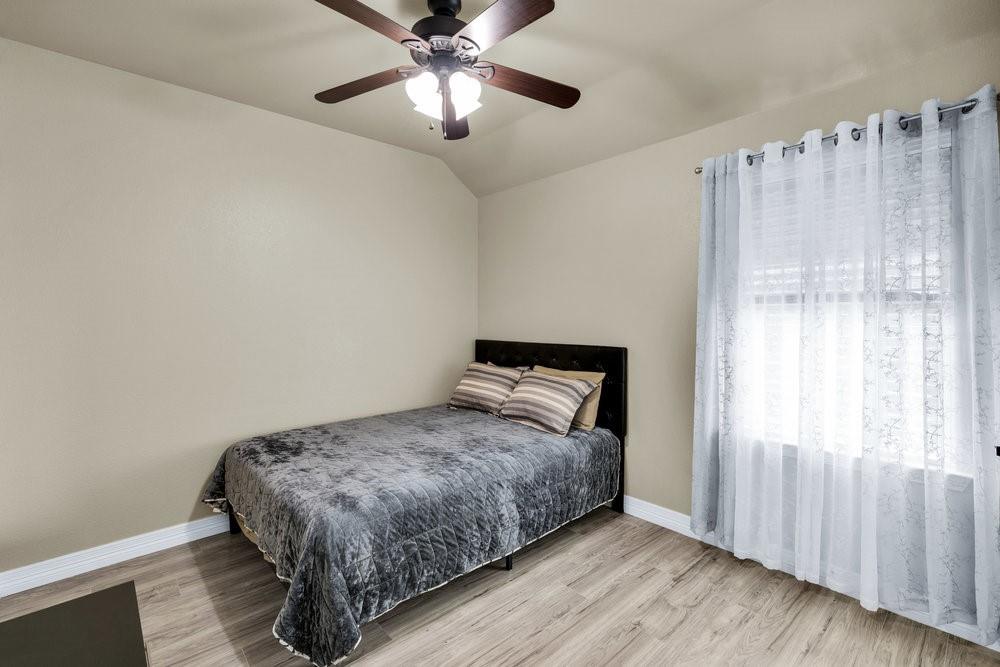 118 Cherokee Street Greenville, TX 75402 - Photo 13 of 19 a bedroom with a bed and a chandelier