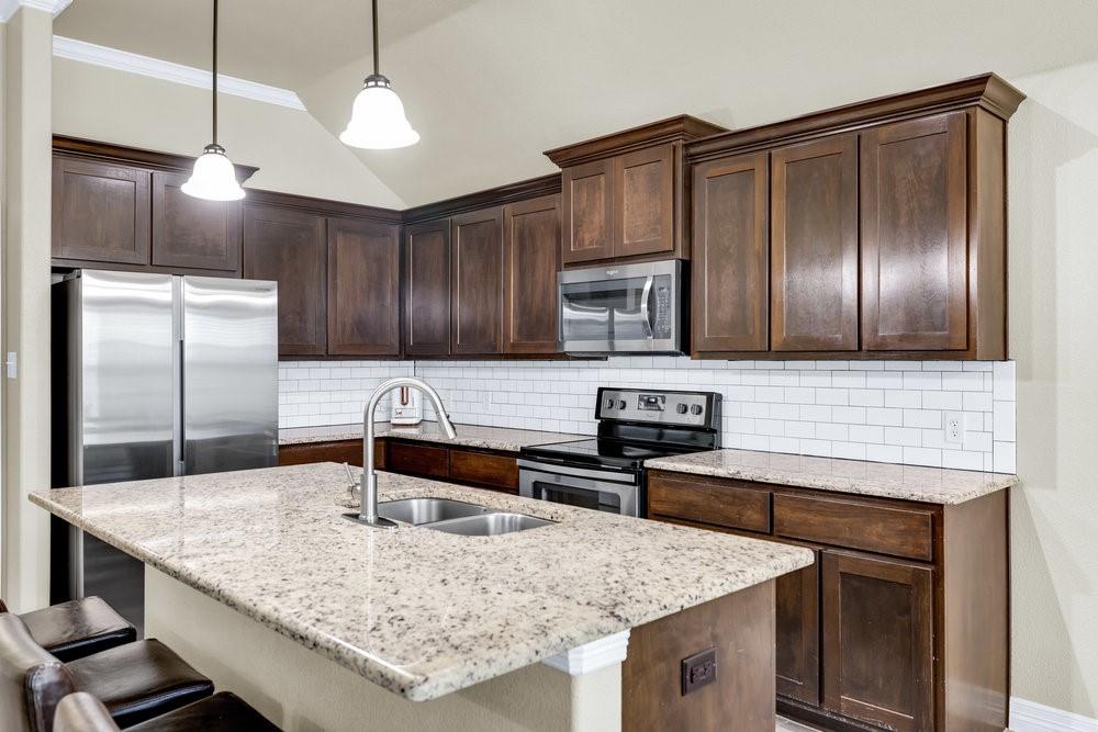 118 Cherokee Street Greenville, TX 75402 - Photo 4 of 19 a kitchen with stainless steel appliances granite countertop a sink refrigerator and microwave