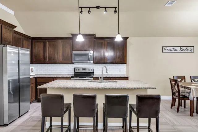 a living room with furniture and a view of kitchen
