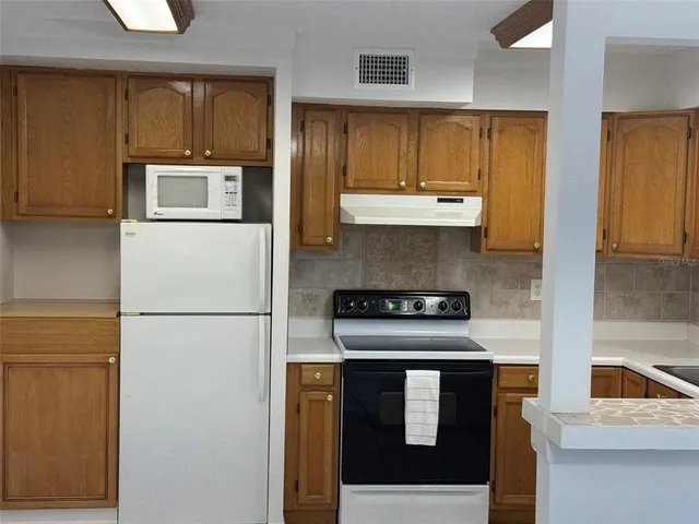 a kitchen with a refrigerator a stove a washer and dryer