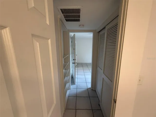 an empty room with closet and a ceiling fan