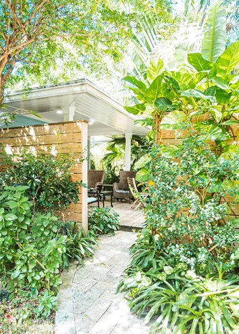 a living room with furniture kitchen view and a large window