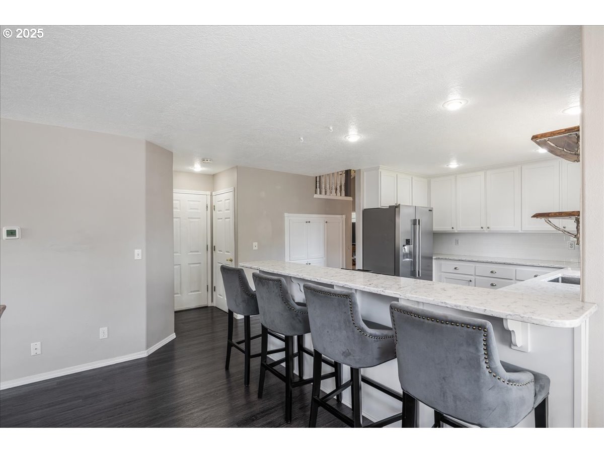 3253 Southeast 24th Terrace Gresham, OR 97080 - Photo 16 of 43 a kitchen with kitchen island wooden cabinets and refrigerator