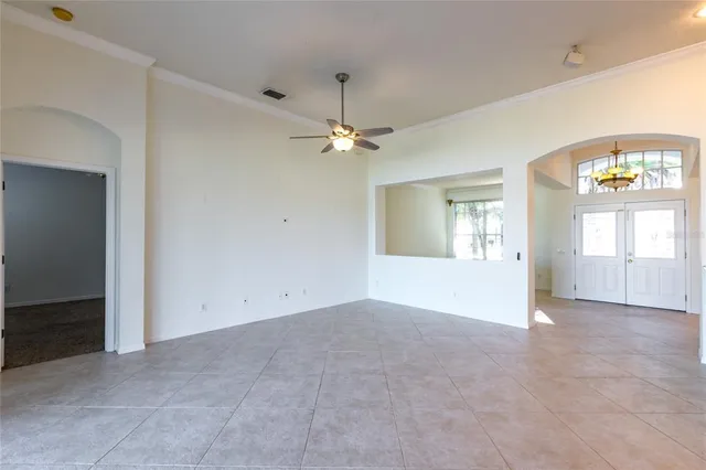 an empty room with fan and windows