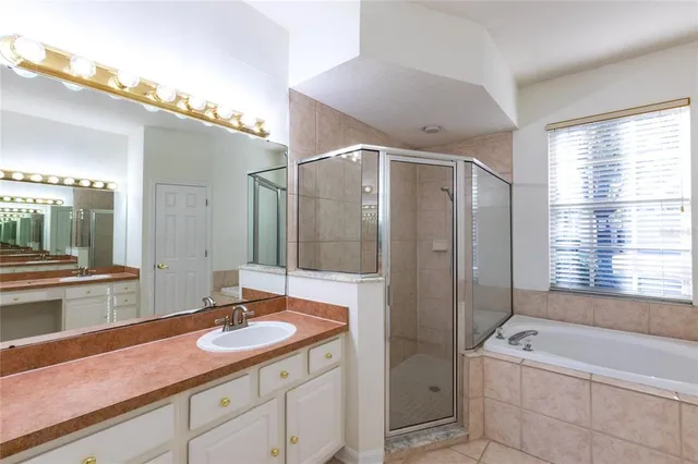 a bathroom with a granite countertop sink a large mirror and a bathtub