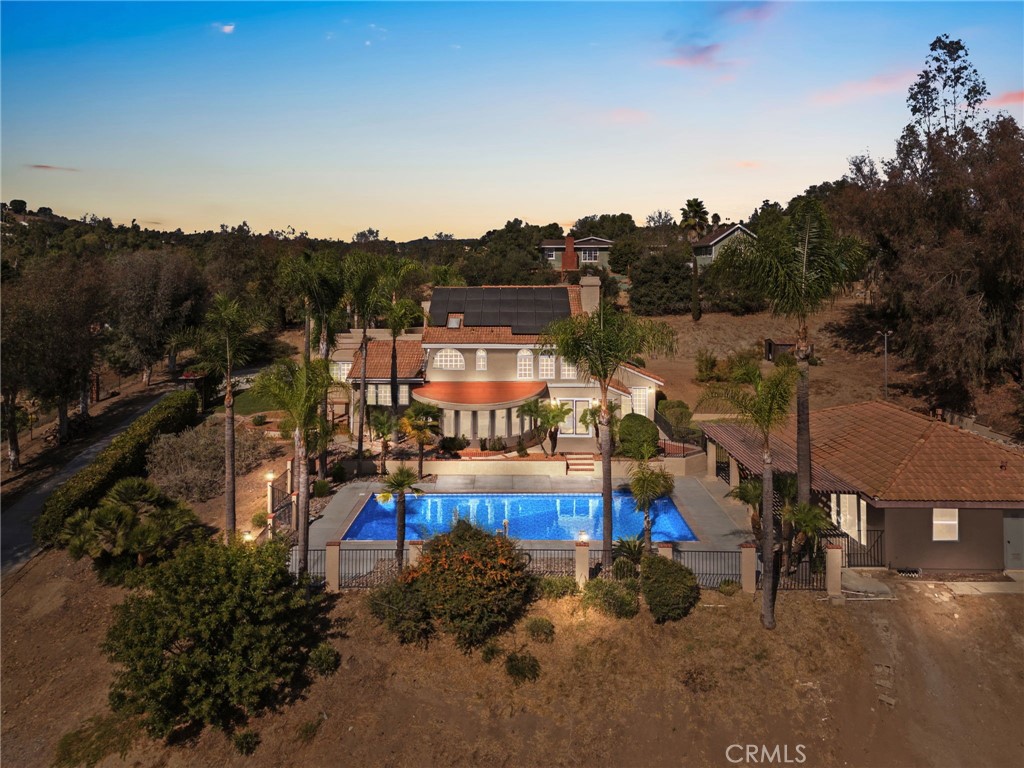 an aerial view of a house with a garden and lake view
