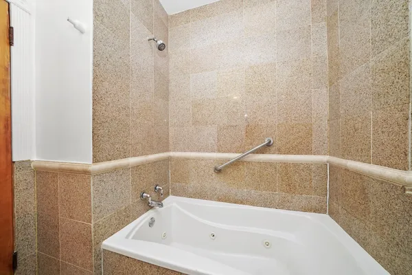 a white bath tub sitting next to a white sink and vanity