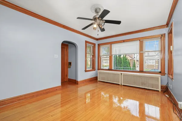 a view of empty room with wooden floor and fan