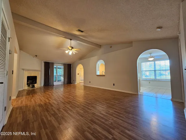 a view of empty room with wooden floor and fireplace