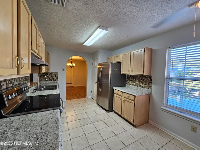 a kitchen with stainless steel appliances granite countertop a stove a sink and a refrigerator