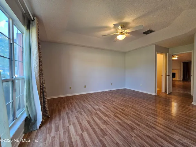 a view of a livingroom with a ceiling fan and hardwood floor