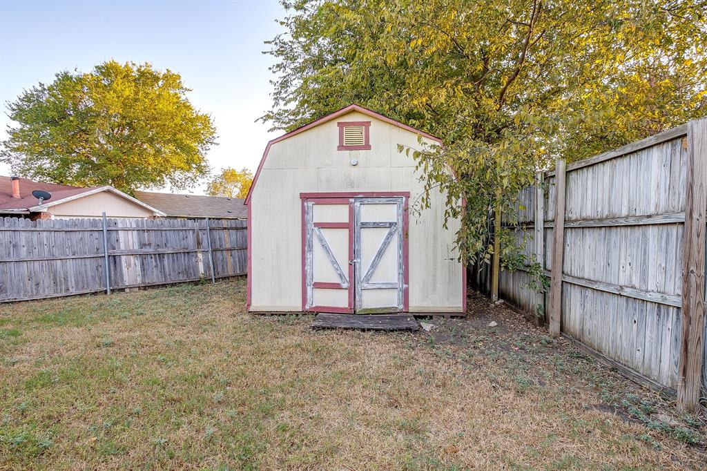 1906 Beacon Way Fort Worth, TX 76140 - Photo 34 of 36 a view of backyard with small cabin and wooden fence