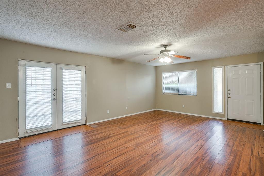 1906 Beacon Way Fort Worth, TX 76140 - Photo 4 of 36 an empty room with wooden floor chandelier and windows
