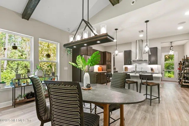 a bedroom with a bed a dresser and potted plants