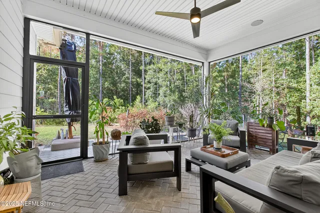 view of an ocean with a floor to ceiling window and potted plants