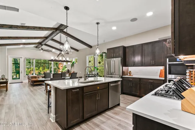 a kitchen with refrigerator a sink and chairs