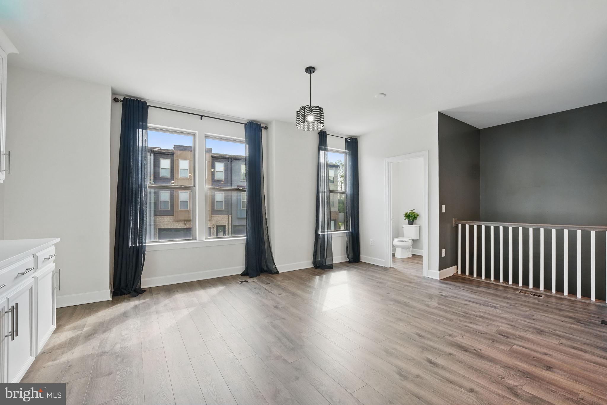 9870 Buchanan Loop Manassas, VA 20110 - Photo 3 of 41 a view of an empty room with wooden floor and a window