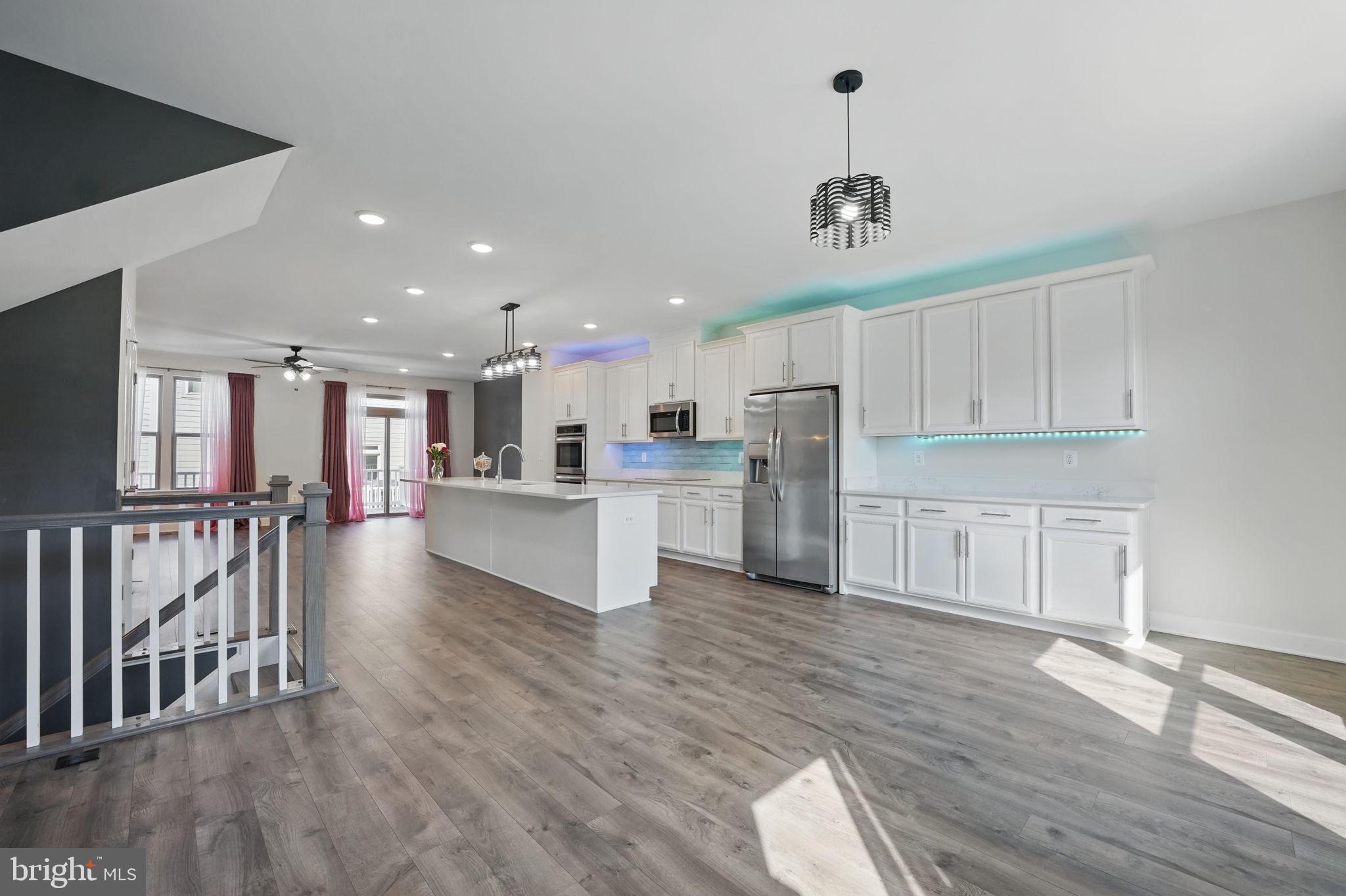 9870 Buchanan Loop Manassas, VA 20110 - Photo 4 of 41 a view of kitchen with center island wooden floor and stainless steel appliances