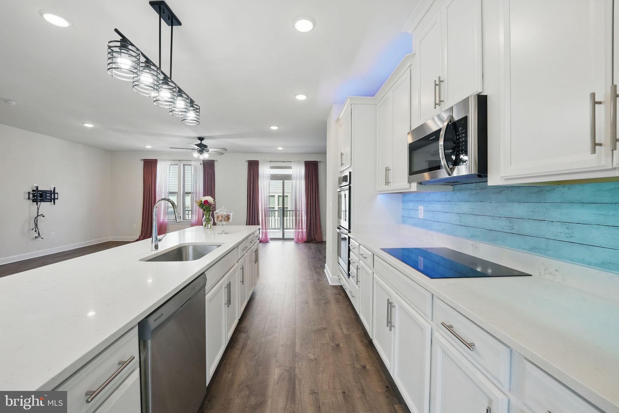 9870 Buchanan Loop Manassas, VA 20110 - Photo 7 of 41 a large kitchen with stainless steel appliances granite countertop a lot of counter space and wooden floor