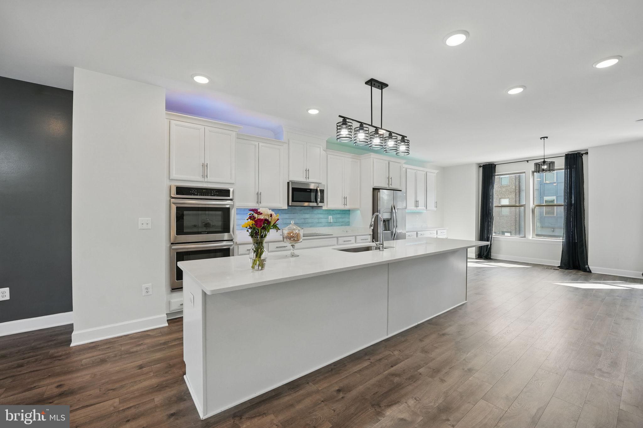 9870 Buchanan Loop Manassas, VA 20110 - Photo 8 of 41 a kitchen with stainless steel appliances a sink dishwasher a refrigerator and a stove with wooden floor