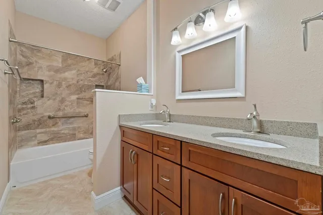 a bathroom with a granite countertop sink a mirror and a bathtub