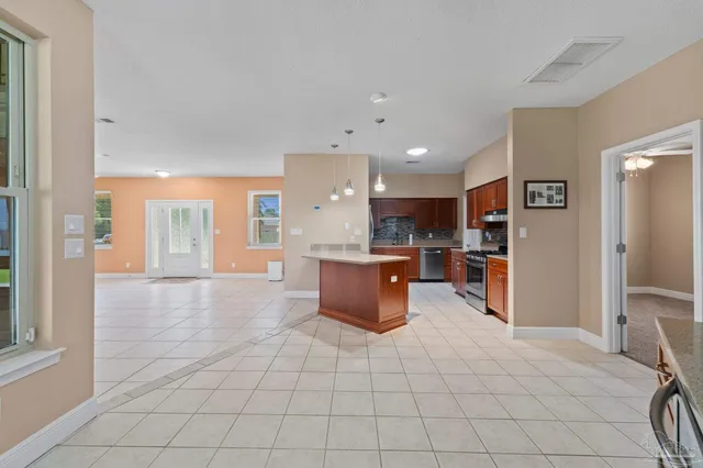 a kitchen with stainless steel appliances granite countertop a stove refrigerator and a sink