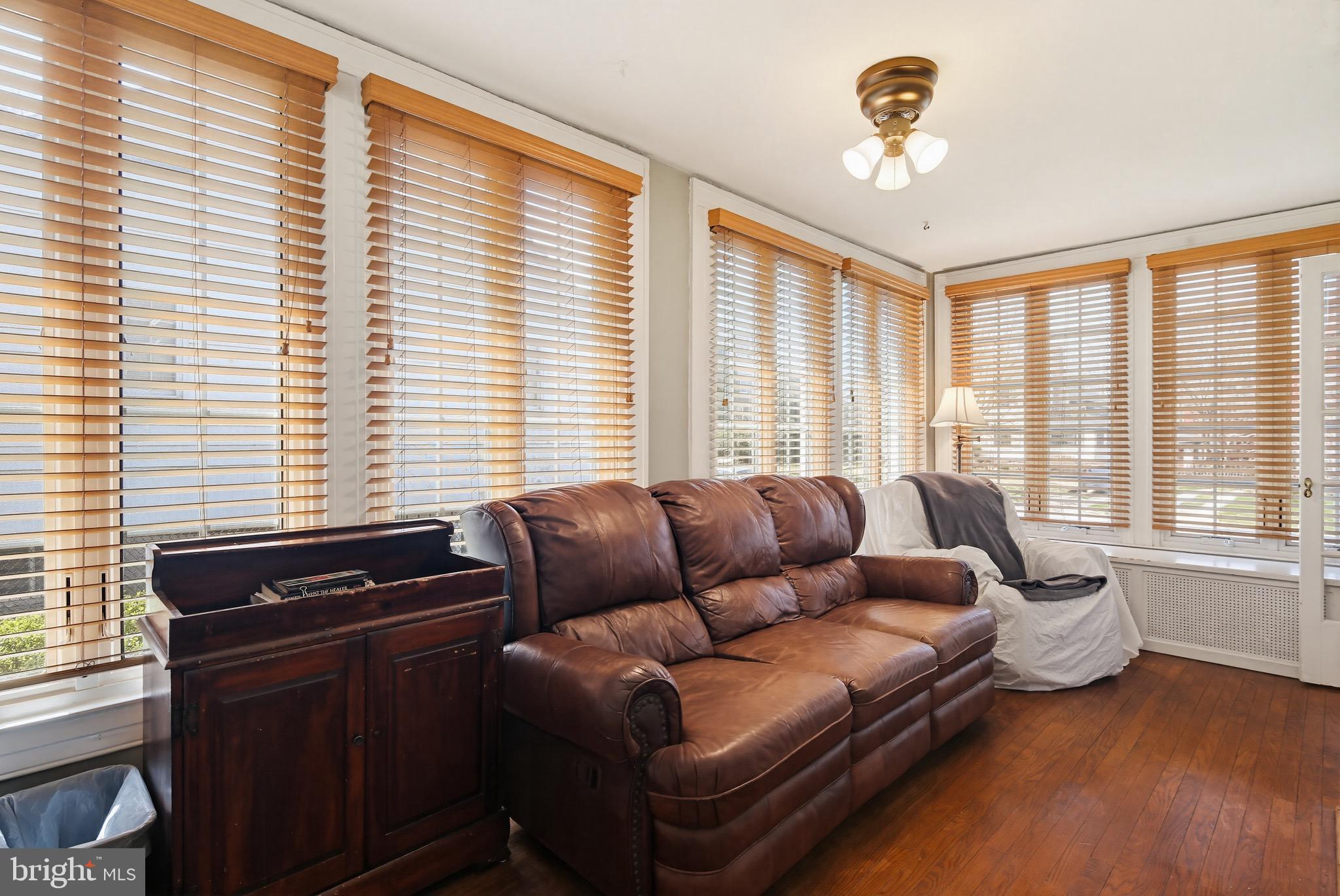 705 Winans Way Baltimore, MD 21229 - Photo 12 of 43 Light-filled sunroom with hardwood floors