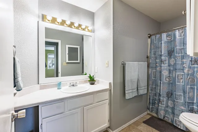 a bathroom with a double vanity sink mirror and shower