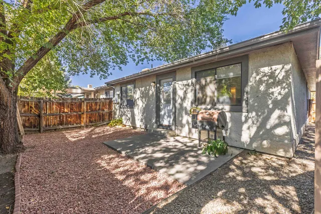 a view of backyard with large trees and wooden fence