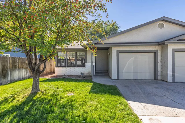 a view of house with backyard and a tree