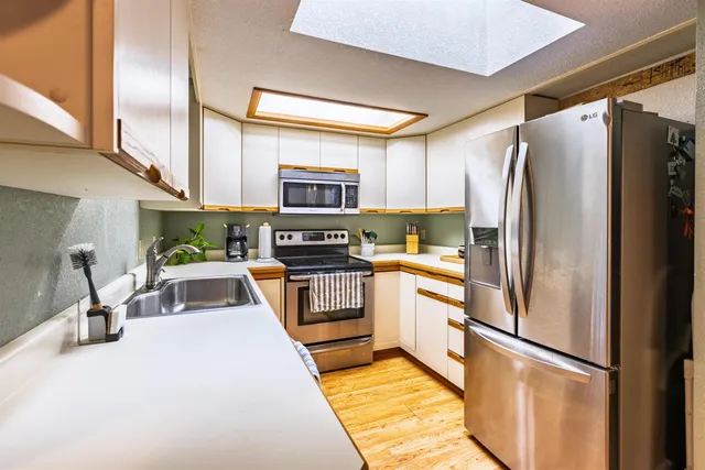 a kitchen with stainless steel appliances a refrigerator sink and microwave