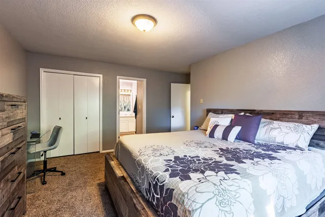 a bedroom with a large bed and a desk