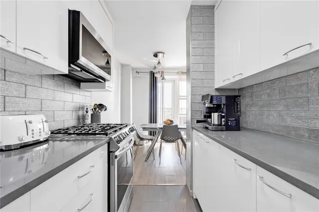 a kitchen with stainless steel appliances granite countertop a sink stove and cabinets
