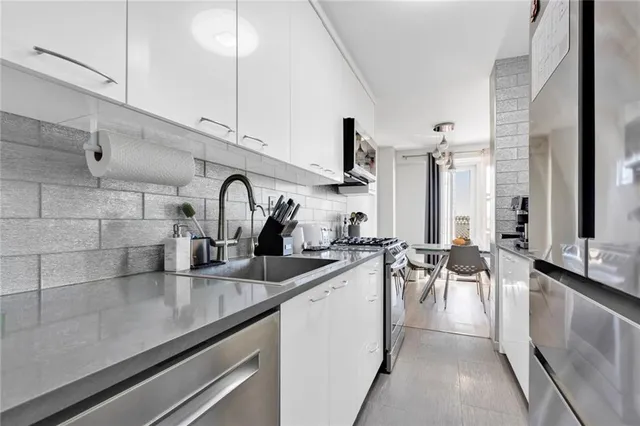 a kitchen with sink a counter and chairs