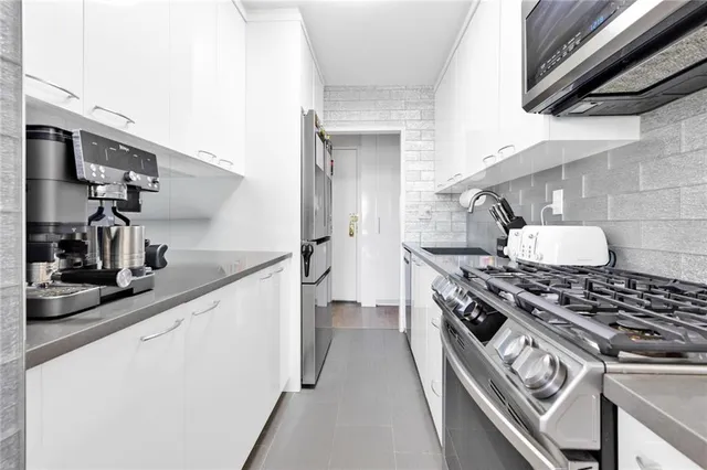 a kitchen with stainless steel appliances granite countertop a stove and a sink
