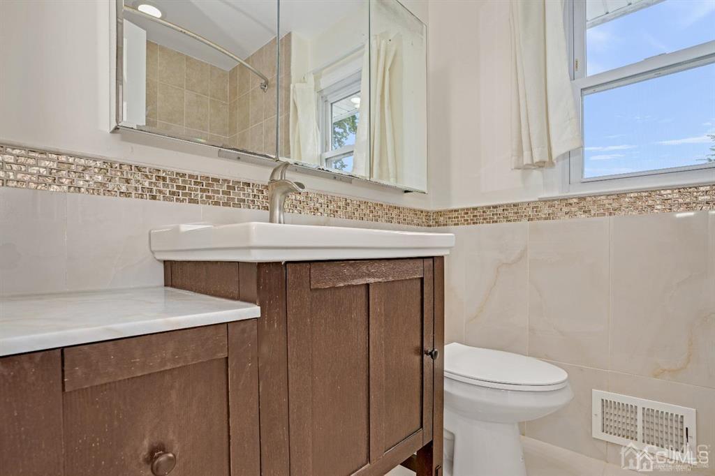 63 South Cliff Road Colonia, NJ 07067 - Photo 21 of 37 a bathroom with a sink a toilet and a mirror