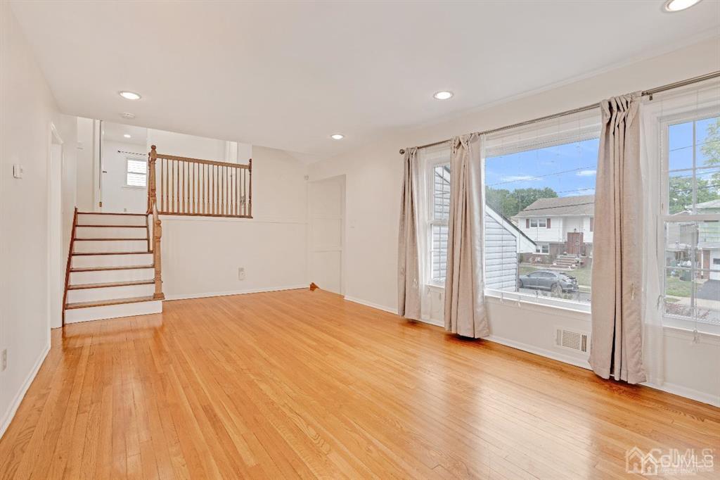 63 South Cliff Road Colonia, NJ 07067 - Photo 5 of 37 a view of an empty room with a window and wooden floor